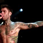 Fedez che canta a petto nudo durante un concerto